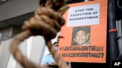 FILE - An activist holds poster against the impending execution of Nagaenthran K. Dharmalingam, sentenced to death for trafficking heroin into Singapore, during a gathering outside the Singaporean Embassy in Kuala Lumpur, Malaysia, April 23, 2022. 