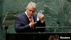 El presidente de Colombia, Iván Duque, se quita la mascarilla protectora que usó debido a la pandemia de la enfermedad por coronavirus (COVID-19) para dirigirse a la 76.ª sesión de la Asamblea General de la ONu en Nueva York, EEUU, el 21 de septiembre de 2021.