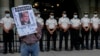 ARCHIVO. Un manifestante sostiene un cartel con un retrato del presidente guatemalteco Alejandro Giammattei frente al Palacio Nacional mientras la gente asiste a una manifestación en apoyo del fiscal anticorrupción Juan Francisco Sandoval, en Ciudad de Guatemala.