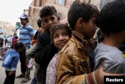 Anak laki-laki mengantre untuk menerima makanan dari dapur amal selama bulan suci Ramadhan di Sanaa, Yaman, 18 April 2022. (Foto: REUTERS/Khaled Abdullah)