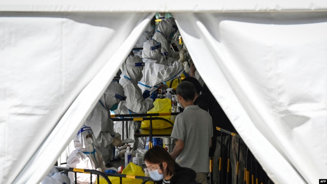 Petugas kesehatan melakukan pengujian virus COVID-19 di tempat pengujian darurat di Zhongguancun, Beijing, 26 April 2022. (Jade GAO/AFP)