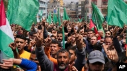 Hamas supporters wave green Islamic flags while raise their hands up and chant slogans during a rally in solidarity with Palestinian residents of the West Bank and Jerusalem, Gaza Strip. April 22, 2022. 