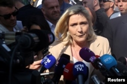 Marine Le Pen, French far-right National Rally (Rassemblement National) party candidate for the 2022 French presidential election, talks to journalists as she visits a local market in Etaples on the last day of campaigning, ahead of the second round of the presidential election, France, April 22, 2022.