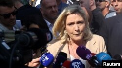 Marine Le Pen, candidata del partido francés de extrema derecha Rally Nacional (Rassemblement National) para las elecciones presidenciales francesas de 2022, habla con los periodistas mientras visita un mercado local en Etaples el último día de campaña, antes de la segunda ronda el 22 de abril de 2022.