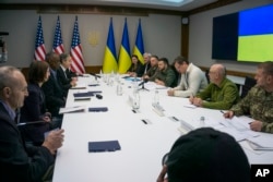 In this image provided by the Department of Defense, Secretary of Defense Lloyd Austin, third from left, and Secretary of State Antony Blinken, right, meet with Ukrainian Foreign Minister Dmytro Kuleba, third from right and Ukrainian President Volodymyr Zelenskyy on April 24, 2022 in Kyiv, Ukraine. (Department of Defense via AP)