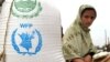 Arhiva - Raseljena Pakistanka, iz severozapadne oblasti Buner, sedi pored džaka sa hranom pristiglim od Svetskog programa za hranu (WFP) Ujedinjenih nacija, u distributivnom centru u Svabiju, 2. maja 2009.