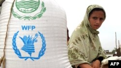 Arhiva - Raseljena Pakistanka, iz severozapadne oblasti Buner, sedi pored džaka sa hranom pristiglim od Svetskog programa za hranu (WFP) Ujedinjenih nacija, u distributivnom centru u Svabiju, 2. maja 2009.