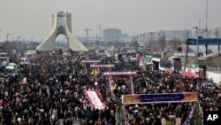 FILE -- Iranians attend an annual rally commemorating the anniversary of the 1979 Islamic revolution, on Azadi (Freedom) Street, while the Azadi tower is seen at rear left, in Tehran, Iran, Feb. 11, 2014. 