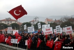 Supporters of President Tayyip Erdogan wave Turkish flags during the first hearing of the trial for soldiers accused of attempting to assassinate Erdogan during last year's failed July 15 coup, in Mugla, Turkey, Feb. 20, 2017.