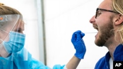 醫務人員在瑞典隆德的斯科訥大學醫院外的帳篷裡進行新冠病毒採樣。(2020年4月29日)
