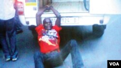 Người đàn ông Mozambique bị còng vào xe cảnh sát Nam Phi