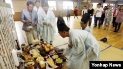 추석 명절을 나흘 앞둔 15일 춘천시 성원초등학교 체육관에서 춘천 지역에 사는 북한이탈주민 50여 명이 합동차례를 지내고 있다.