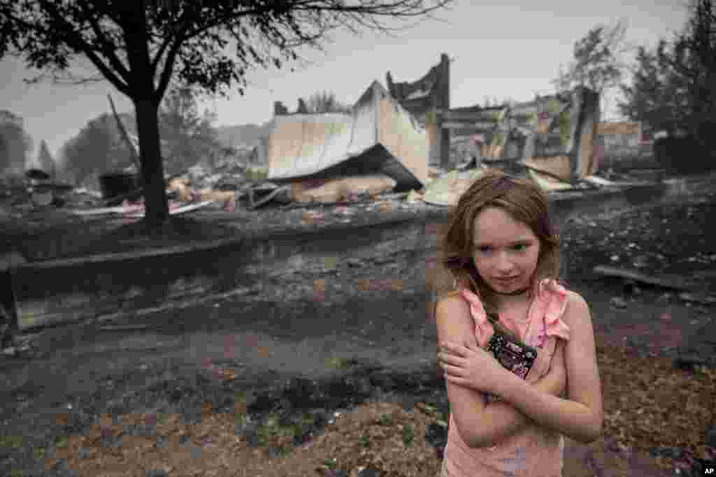 Ellie Owens, de 8 años, de Grants Pass, Oregon, observa los daños causados ​​por el fuego el 11 de septiembre de 2020, mientras los incendios forestales devastaban la región. [Foto: Paula Bronstein]