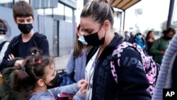 Seorang perempuan Ukraina bersama anak-anaknya antre untuk mengajukan suaka ke AS di kota Tijuana, Meksiko (foto: dok). 