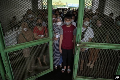 Warga mengantre untuk menerima suntikan vaksin COVID-19 di Stadion Patriot Candrabhaga, Bekasi, Selasa, 8 Februari 2022. (Foto: AP/Achmad Ibrahim)