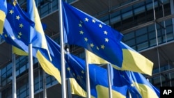 FILE - European and Ukraine flags fly outside the European Parliament, March 8, 2022 in Strasbourg, eastern France. 