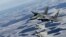 Літак військово-повітряних сил Польщі (згори) MIG-29 та італійські літаки Eurofighter Typhoon під час патрулювання над Балтією 10 лютого 2015 р.