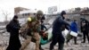 A person is carried as people flee near a destroyed bridge to cross Irpin River as Russia's invasion on Ukraine continues, in Irpin outside Kyiv, Ukraine, March 9, 2022. 