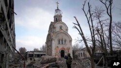 Ukrajinski vojnik fotografiše teško oštećenu crkvu nakon bombardovanja stambenog dela grada Mariupolja, 10. marta 2022.