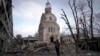 A Ukrainian serviceman takes a photograph of a damaged church after shelling in a residential district in Mariupol, Ukraine, March 10, 2022.