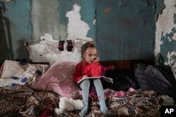 Seorang gadis duduk di tempat penampungan di Mariupol, Ukraina, Senin, 7 Maret 2022. (Foto: AP/Evgeniy Maloletka)