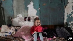 Seorang anak perempuan duduk di dalam tenda perlindungan sementara dari bom di Mariupol, Ukraina, pada 7 Maret 2022. (Foto: Foto: AP/Evgeniy Maloletka)