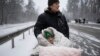 An elderly woman is coated in snow as she is evacuated in a wheelchair from Irpin, on the outskirts of Kyiv, Ukraine, March 8, 2022. 