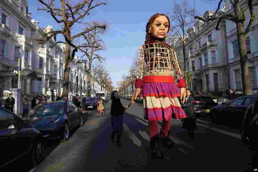 Refugee puppet Little-Amal makes an appearance in London outside the Ukrainian Embassy to bring attention to the situation of people fleeing the Russian invasion of Ukraine. (AP Photo/Alastair Grant)