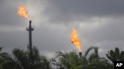 FILE - Gas flares from the Agip Oil company are seen across farmland in Idu, Niger Delta area of Nigeria. Gas flares are created by oil drilling and pumping. Taken 10.8.2021