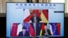 屏幕显示中国领导人习近平、法国总统马克龙和德国总理朔尔茨在视频会议上商讨乌克兰危机问题。（2022年3月8日）