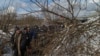 Civilians that were trapped in the little town of Irpin escape from the battles through an improvised path created alongside a bombed bridge by Ukrainian forces, in Irpin, Ukraine, March 8, 2022. (Yan Boechat/VOA)