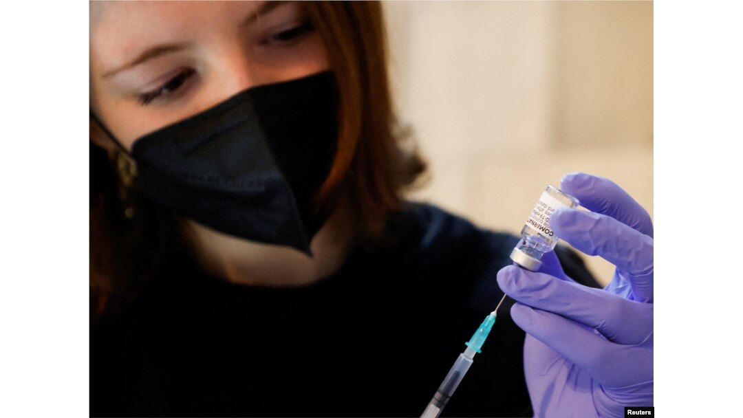 Seorang sukarelawan menyiapkan jarum suntik berisi dosis Comirnaty, vaksin COVID-19 Pfizer-BioNTech, di pusat vaksinasi di Katedral St. Stephen, di Wina, Austria, 5 Februari 2022. (REUTERS/Leonhard Foeger)