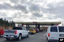 Cars line up for gas at a Costco store in Lacey, Wash., March 7, 2022.