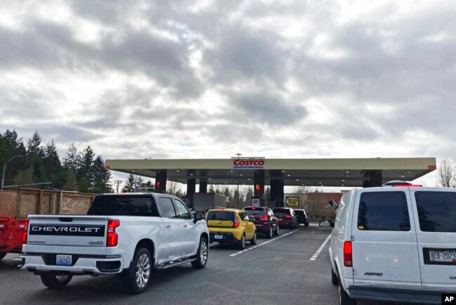 Cars line up for gas at a Costco store in Lacey, Wash., March 7, 2022.