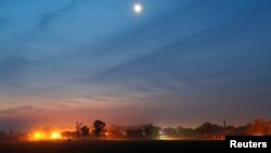 FILE - The illuminated fenced border between India and Pakistan is pictured at a village in Ranbir Singh Pura sector near Jammu, March 1, 2019. 