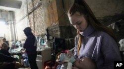 ইউক্রেনের একটি আশ্রয় শিবিরে বাচ্চাকে দুধ খাওয়াচ্ছেন একজন নারী। মার্চ ৭ ২০২২। (ছবি- এপি) 