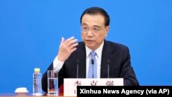 资料照：中国总理李克强在北京人大会堂全国人大会议闭幕后举行的记者会上讲话的照片。（2022年3月11日）