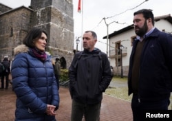 Oihana Goiriena, wife of Spanish journalist Pablo Gonzalez, talks to Spanish congressman Jon Inarritu and EH Bildu parliamentarian Unai Urruzuno, during a rally in Nabarniz, Spain, March 6, 2022.