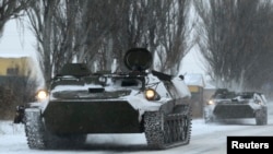 FILE - An unmarked armored personnel carrier is seen on the road from Luhansk to Donetsk in the territory controlled by the self-proclaimed Donetsk People's Republic, eastern Ukraine, December 1, 2014.