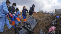 Warga Ukraina memasukkan jenazah korban perang ke kuburan massal di pinggiran kota Mariupol, Ukraina, 9 Maret 2022, karena orang tidak dapat menguburkan mereka di tengah tembakan artileri pasukan Rusia (ilustrasi). 