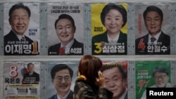 지난 7일 한국 서울 시민이 대선 후보 포스터 앞을 지나고 있다. 