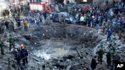 FILE - Rescue workers and soldiers stand around a massive crater after a bomb attack that tore through the motorcade of then-Prime Minister Rafik Hariri, in Beirut, Lebanon, Feb. 14, 2005.