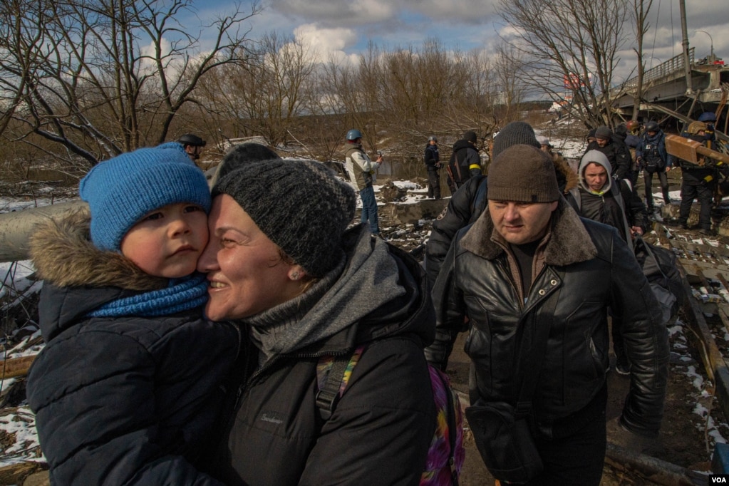 A woman embraces her son after escaping the little town of Irpin, on the outskirts of Kyiv, Ukraine, March 8, 2022. Thousands of civilians were trapped in the city, which has been a battleground for Ukrainian and Russian forces. (Yan Boechat/VOA) 