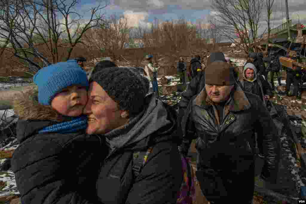 A woman embraces her son after escaping the little town of Irpin, on the outskirts of Kyiv, Ukraine, March 8, 2022. Thousands of civilians were trapped in the city, which has been a battleground for Ukrainian and Russian forces. (Yan Boechat/VOA) 