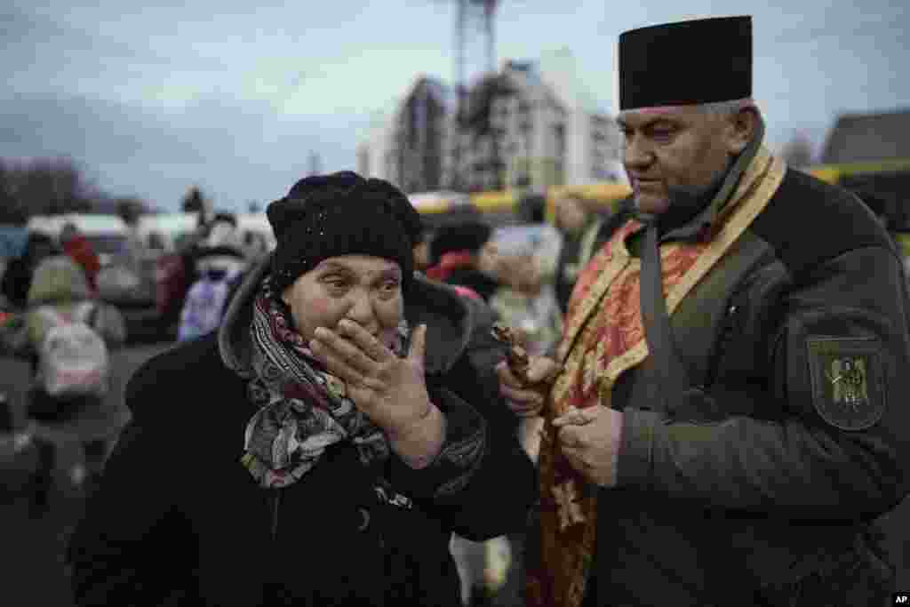 A military priest comforts a woman who was evacuated from Irpin, at a triage point in Kyiv, March 9, 2022.&nbsp;A Russian airstrike devastated a maternity hospital in the besieged port city of Mariupol amid growing warnings from the West that Moscow&#39;s invasion is about to take a more brutal and indiscriminate turn.