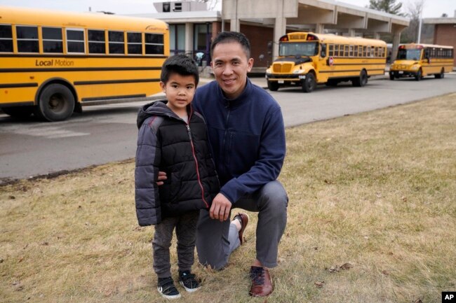 Jason Chan, right, kneels next to his 5-year-old son Skyler, both of Needham, Mass. (AP Photo/Steven Senne)