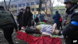 Ukrajinske hitne službe i volonteri iznose povrijeđenu trudnicu iz bolnice u Marijupolju, 9. mart 2022. (Foto: AP/Evgeniy) Maloletka)