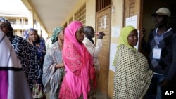 FILE - Women wait to cast their votes during elections, in Briqueterie, Cameroon, Oct. 7, 2018. On Tuesday, coinciding with Women's Day, women in Cameroon rallied demanding broader political power in the country. 