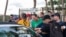 FILE - Baseball fans crowd around a car to get autographs from New York Yankees pitcher Gerrit Cole, who was attending MLB contract negotiations at Roger Dean Stadium in Jupiter, Florida, Feb. 23, 2022. 