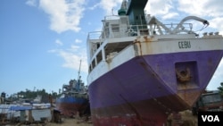 Beached ships among shanties along this seaside community of Anibong. The city says shipping companies have been given months to remove the ships, if not the government will move them, Tacloban City, Philippines, March 9, 2014. (Simone Orendain for VOA)